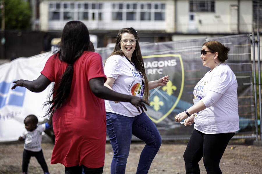 Women from different backgrounds dancing together at a ZNVA community celebration in Newport